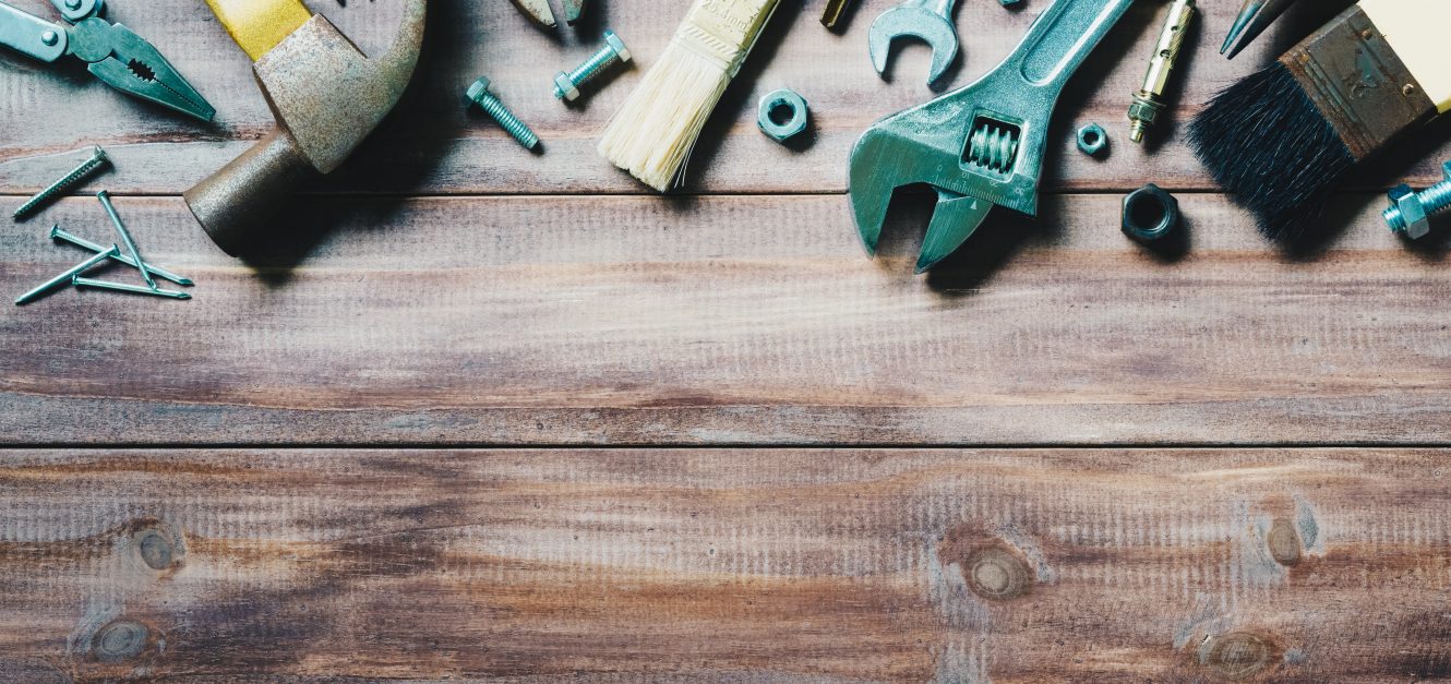 Assorted tools on wood background
