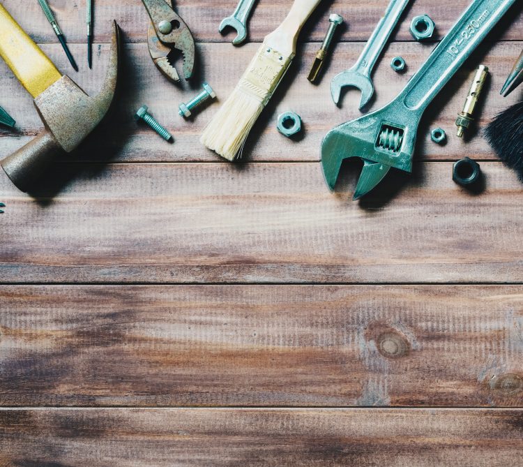 Assorted tools on wood background