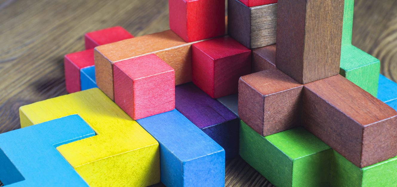 Multi-size and shaped colored wood blocks stacked randomly on wood surface