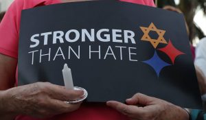 Woman holding sign that says "Stronger than hate"